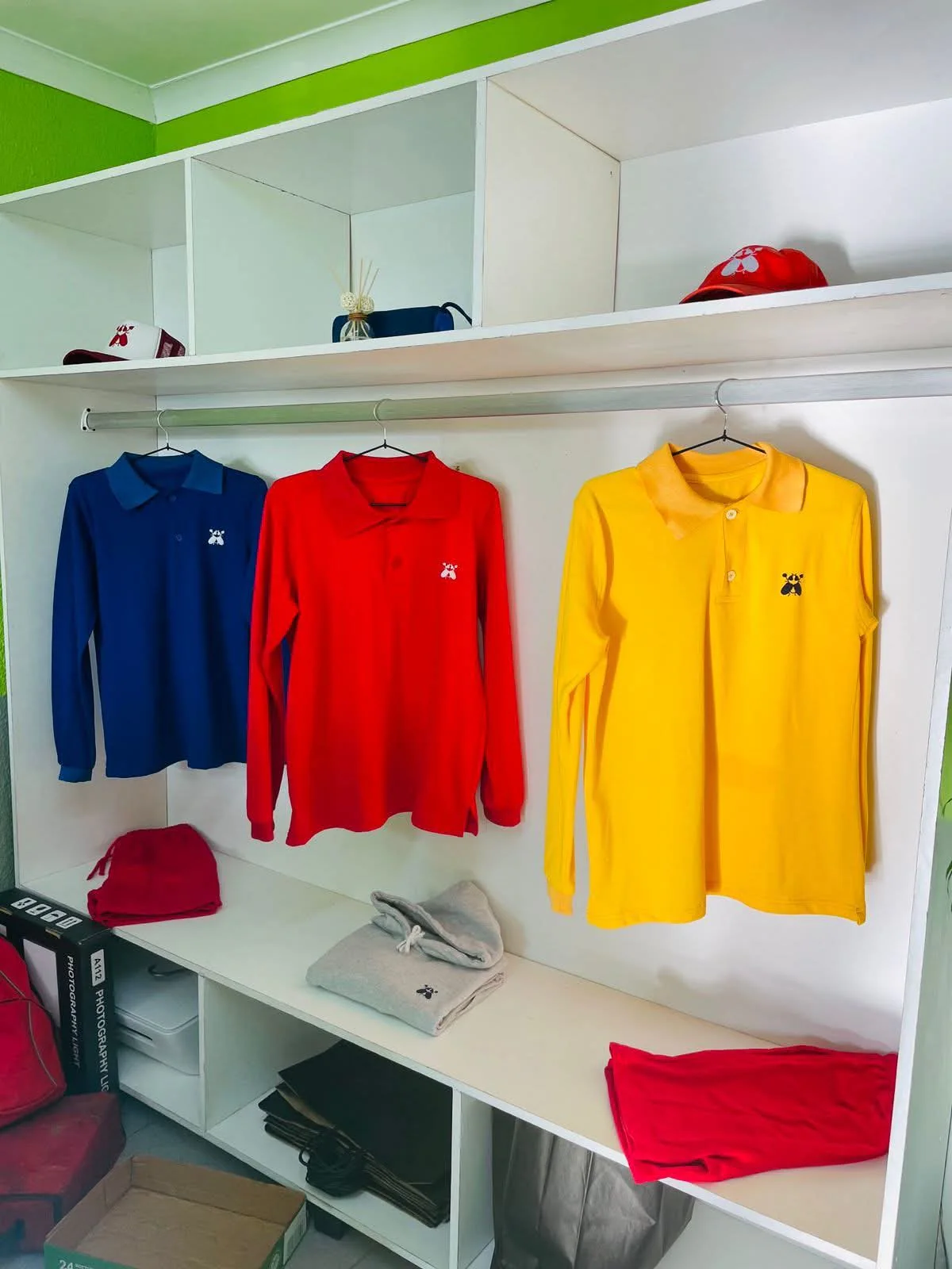 A SACXESS store display of long-sleeve tops and caps